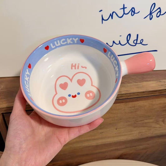 Ceramic bowl with cartoon design and text on a wooden surface