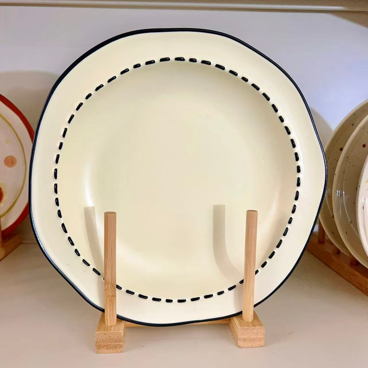 Four macaron color ceramic plates: off-white, yellow, matcha green, pink with manga style black rim