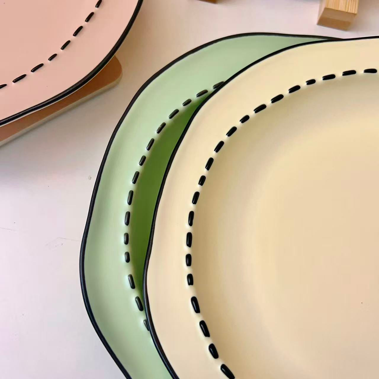 Four macaron color ceramic plates: off-white, yellow, matcha green, pink with manga style black rim