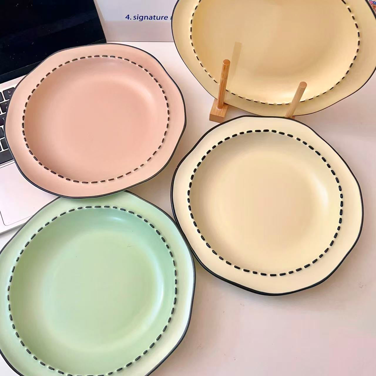 Four macaron color ceramic plates: off-white, yellow, matcha green, pink with manga style black rim