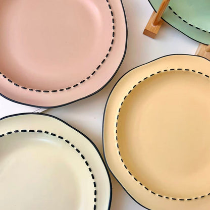 Four macaron color ceramic plates: off-white, yellow, matcha green, pink with manga style black rim