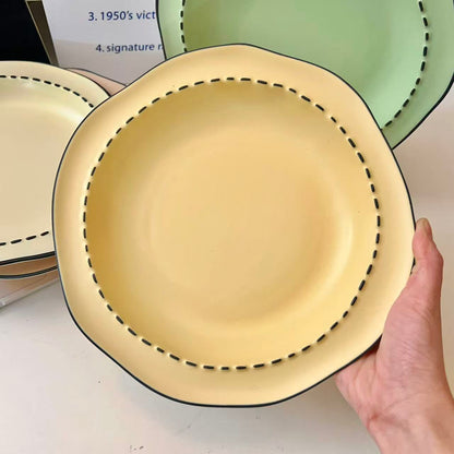 Four macaron color ceramic plates: off-white, yellow, matcha green, pink with manga style black rim